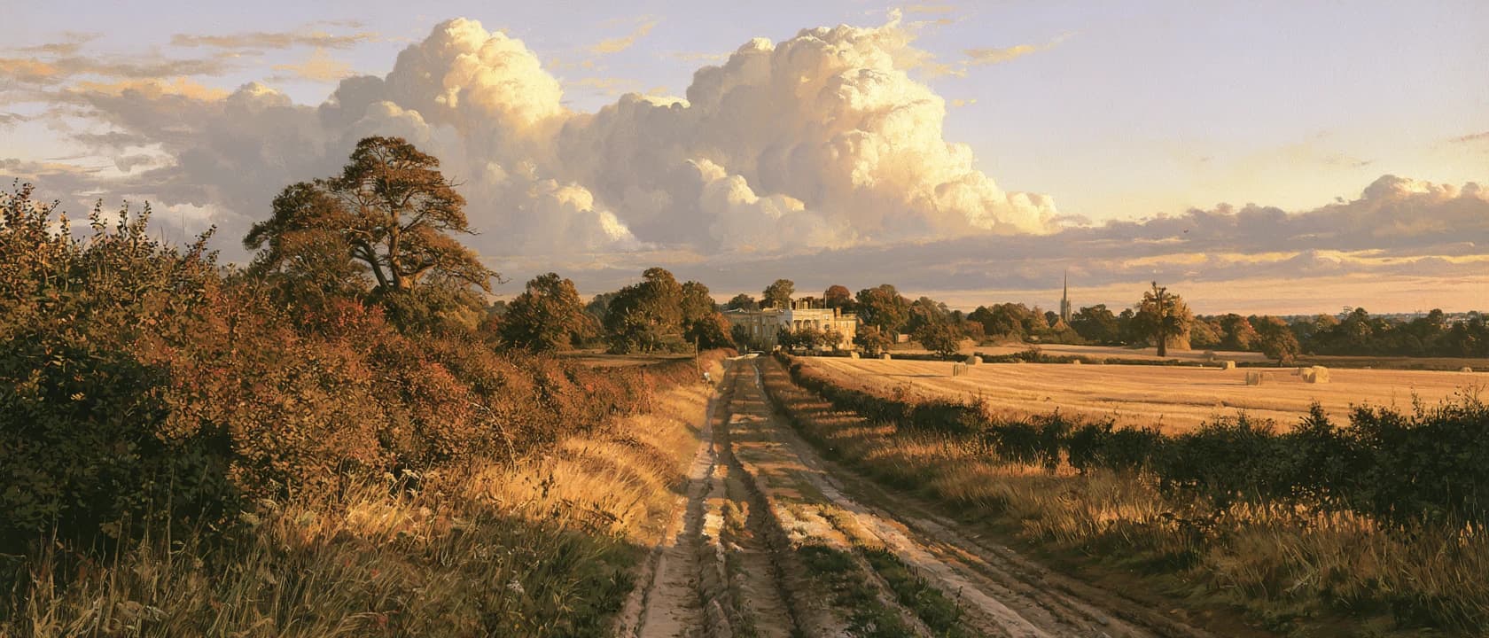 A chalk lane between hawthorn hedgerows running toward a distant Georgian house at golden hour